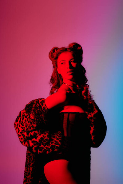 Стильная молодая женщина демонстрирует свой модный наряд в увлекательной, уверенной позе.