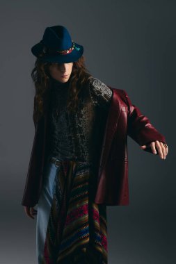 Yakışıklı genç bir adam karizma yayar, şık bir kıyafet giyip, kendine güvenerek poz verir..