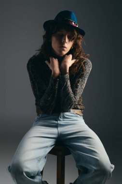 Yakışıklı bir adam kendine güvenerek poz verir, şık kıyafetler giyer ve kapalı bir stüdyoda şık giyinir..