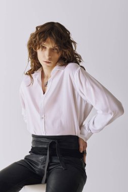 Genç adam kendine güvenen duruşu ve modaya uygun kıyafetleriyle zahmetsiz bir tarz ve cazibe sergiliyor.