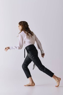 Yakışıklı bir adam zarif bir stüdyoda modern moda ve zahmetsiz bir stil sergiliyor..