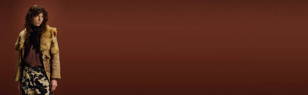 Красивый молодой человек демонстрирует свой уникальный стиль в шикарном наряде посреди роскошной атмосферы.