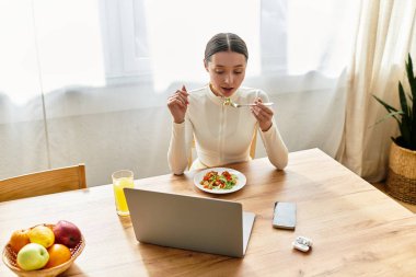 Genç bir kadın besleyici bir yemek yiyor, rahat bir mutfak ortamındaki her lokmanın tadını çıkarıyor..