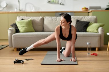 Modern bir dairede, siyah spor giysili genç bir kadın kasıtlı olarak egzersiz yapıyor..