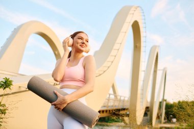 Genç atletik kadın müzik dinlerken yoga antrenmanına hazırlanıyor..