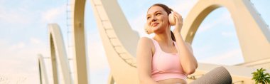 Atletik kadın, altın saatinde modern bir fon karşısında müzik dinlemekten hoşlanıyor..