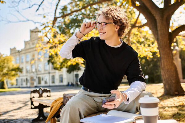 A handsome man studies outdoors, surrounded by fall foliage and historic architecture.
