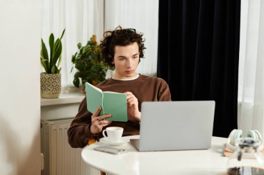 Kıvırcık saçlı genç bir adam, rahat ve çağdaş bir dairede dikkatle çalışıyor..