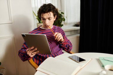 Genç, ikili olmayan bir birey modern dairesinde rahatlar ve çalışmaya odaklanır..