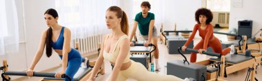 Katılımcılar geniş bir stüdyoda zorlu pilates egzersizleri yaparken yoğun bir şekilde odaklanıyorlar..