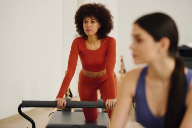 Pilates antrenmanına kendini adamış iki kişi, güç ve esnekliği vurguluyor..