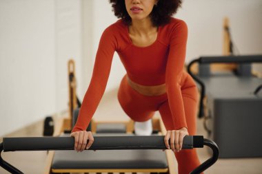 Kendini işine adamış bir insan güç ve dengeyi arttırmak için zorlu bir pilates rutiniyle uğraşır..