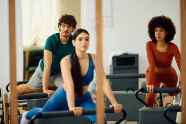 Katılımcılar, özverili bir pilates seansı sırasında sakin bir stüdyoya odaklanıyorlar..