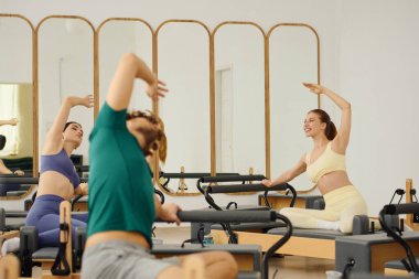 Katılımcılar dinamik bir pilates kursuna katılarak esnekliği ve çekirdek gücünü artırıyorlar.