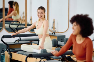 İki kadın enerji dolu bir pilates seansına katılıyor, bağlılıklarını ve güçlerini sergiliyorlar..