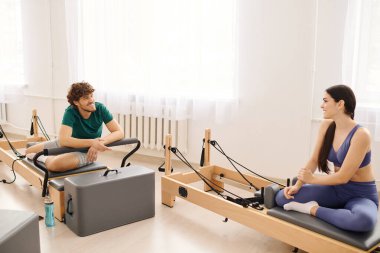 İki insan güneşli, modern bir pilates stüdyosunda hafif bir anın tadını çıkarırlar..