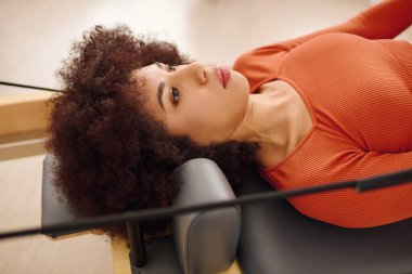 Adanmış bir birey pilates egzersizi yapar, bağlılık ve atletizm gösterisi yapar.