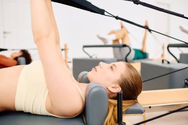 Kendini adamış bireyler, dayanıklılık ve esnekliği artırmak için çeşitli pilates egzersizleri yaparlar..