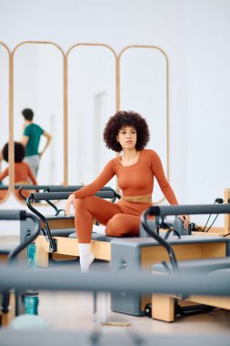 Odaklanmış bir insan sakin bir stüdyoda pilates yapar, güç ve konsantrasyon gösterir..