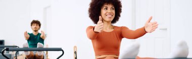 İki hevesli katılımcı, parlak bir pilates stüdyosunda vücutlarını esnetip güçlendiriyor..