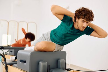 İki kişi pilates yapıyor, sakin bir stüdyoda güç ve esneklik gösteriyor..
