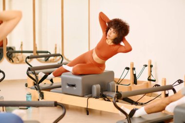 Katılımcılar bir karşılama stüdyosunda dinamik bir pilates dersinde güç ve denge gösteriyorlar..