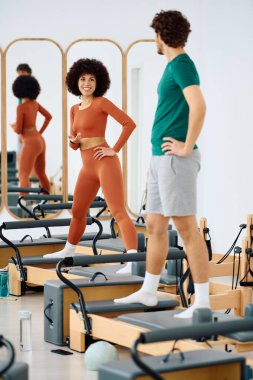 Eğitmen katılımcıya parlak ve davetkar bir alanda dinamik pilates çalışmasında rehberlik eder.