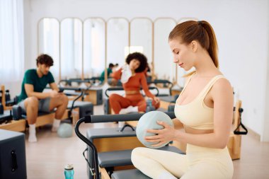 Odaklanmış bireyler, güç ve esnekliği artırmak amacıyla barışçıl bir pilates oturumuna katıldılar.