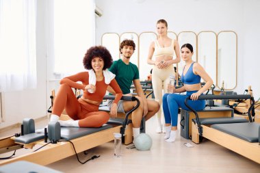 Dört arkadaş dinamik bir pilates sınıfında oyuncu pozlar ve dostluk sergiliyorlar..