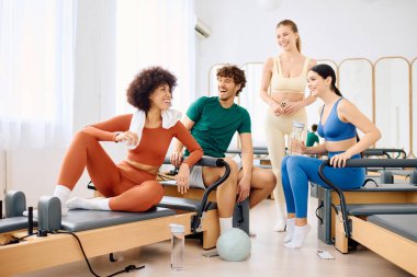 Bir grup birey, canlı bir pilates stüdyosunda antrenman yapmaktan zevk alıyor.