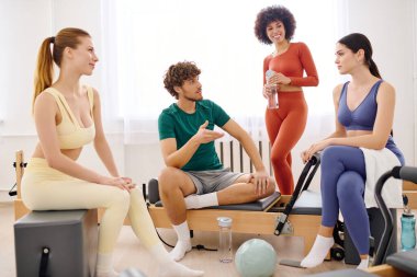 Güneşli bir pilates egzersizi sırasında dört kişi kahkahalarını ve sezgilerini paylaşıyor..