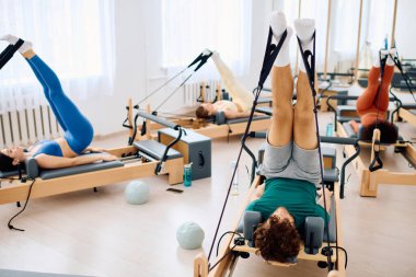 Katılımcılar dinamik pilates yaparak reformcuların çekirdek gücünü ve esnekliğini artırıyorlar..