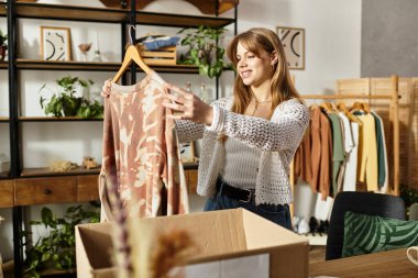 Giysilerini ayıran genç bir kadın, bağışlamak için bir gülümseme ile eşyalar seçiyor..