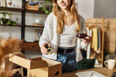 Genç bir kadın bağış için kıyafet tasnif ediyor, sürdürülebilir bir yaşam tarzı girişimini destekliyor.