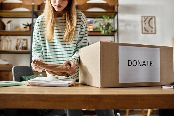 Молодая женщина тщательно организует и готовит одежду для пожертвования в своем уютном жилом помещении.