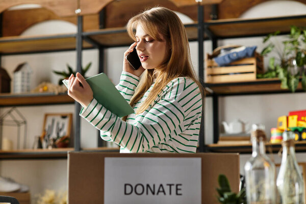 Разбираясь со своей одеждой, молодая женщина разговаривает по телефону, содействуя устойчивости.