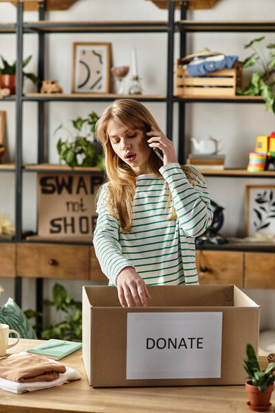 A young woman sorts her clothes for donation while engaging in a phone call about sustainability