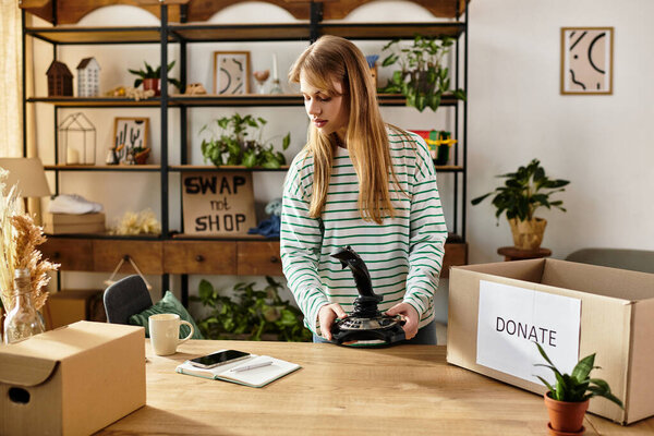 Pretty young woman sorts through her clothes, preparing items for donation and recycling.