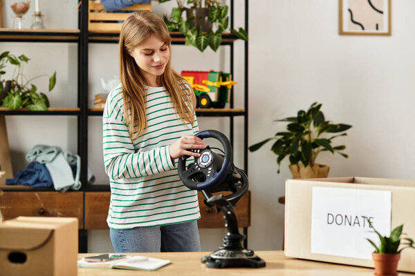 A young woman sorts through items, preparing her goods for donation in her home.