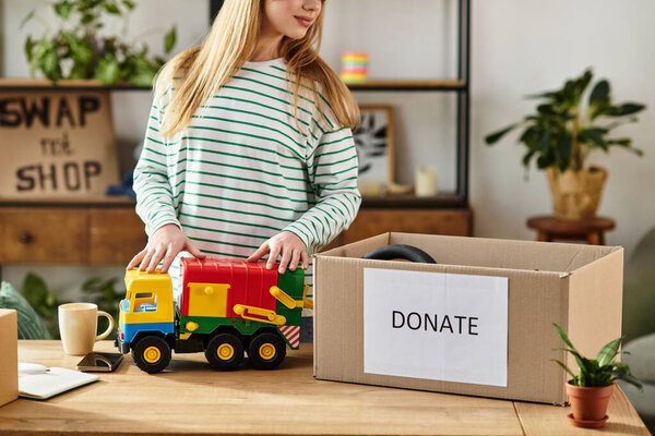 Young woman sorts through clothing and toys, preparing donations for those in need with care.