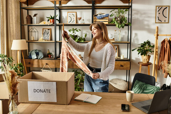 A woman happily organizes her clothing donations, embracing a sustainable lifestyle at home.