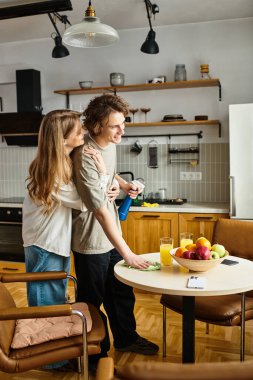 Genç bir çift, güzel evlerinin mutfağında sıcaklığını ve neşesini paylaşarak birbirlerine eşlik etmekten zevk alır..