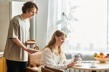 Genç bir çift evde güzel bir anı paylaşıyor. Kahvaltıdan ve birliktelikten keyif alıyorlar..