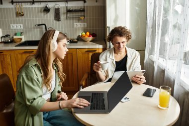 Genç bir çift keyifli bir anın tadını çıkarır, rahat mutfaklarında işleri dengeler ve dinlenirler..
