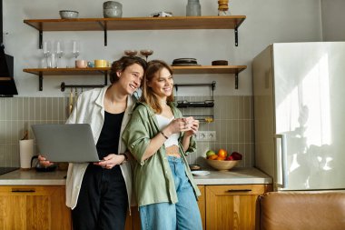 Sevgi dolu bir çift, rahat mutfaklarında gülümseme ve mutluluğu paylaşırken rahat bir anın tadını çıkarır..