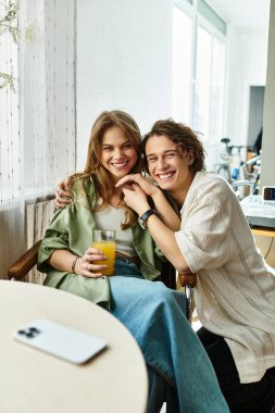 Hoş bir çift, şık, rahat evlerinde kucaklaşırken güler ve içkiden zevk alır..