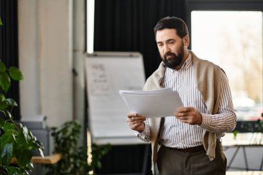 Şık, yaşlı bir adam, parlak ve sakin bir ofiste önemli gazeteler okur..