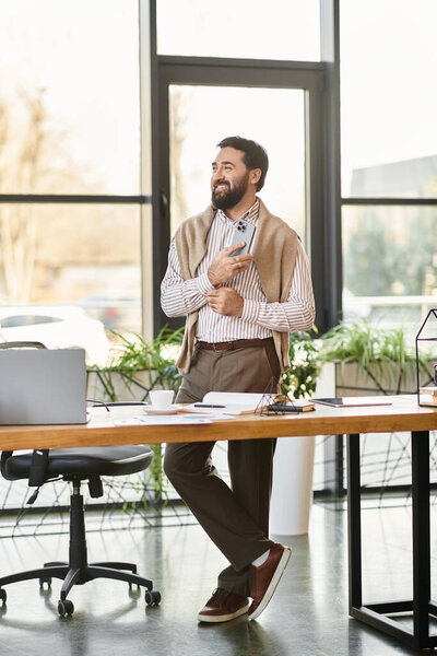 Confident elderly man in casual attire stands in a bright, plant filled office.