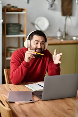Sıradan giyinmiş yaşlı bir adam coşkuyla sanal bir toplantıya katılıyor..