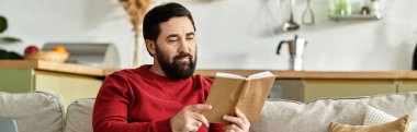 Yaşlı yakışıklı bir adam bir kanepede rahatça dinlenirken bir kitaptan keyif alıyor, huzur saçıyor..